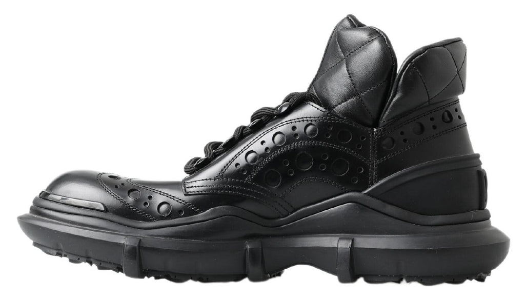 Bottes décontractées en cuir noir de la marque Dolce & Gabbana, ankle, style casual, visibles en gros plan.