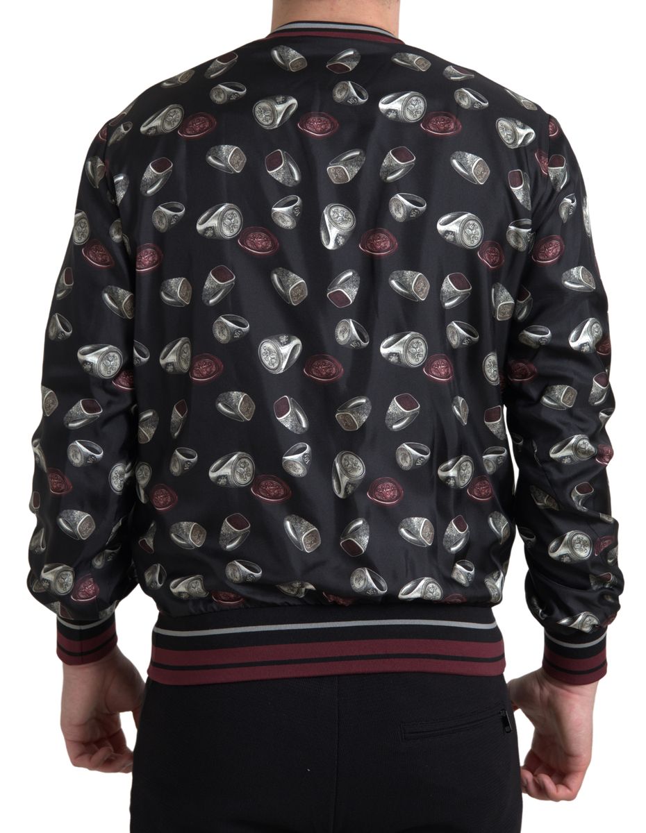 Pull en soie noir Dolce & Gabbana avec motif de bagues, col rond et style élégant visible sur l'image.