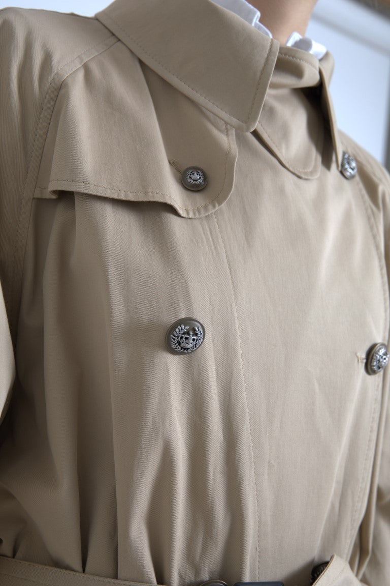 Manteau trench beige double-breasted Dolce & Gabbana en tissu léger, avec ceinture et revers classiques.