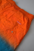 Shorts de plage Dolce & Gabbana en dégradé orange et bleu, maillot de bain léger pour homme, détails colorés et style sophistiqué.