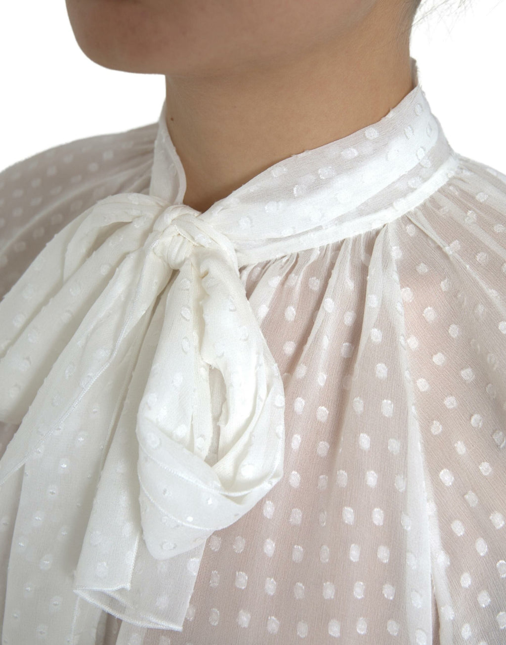 Blouse en soie blanche Dolce & Gabbana à pois, transparente avec nœud au cou, style élégant et sophistiqué.
