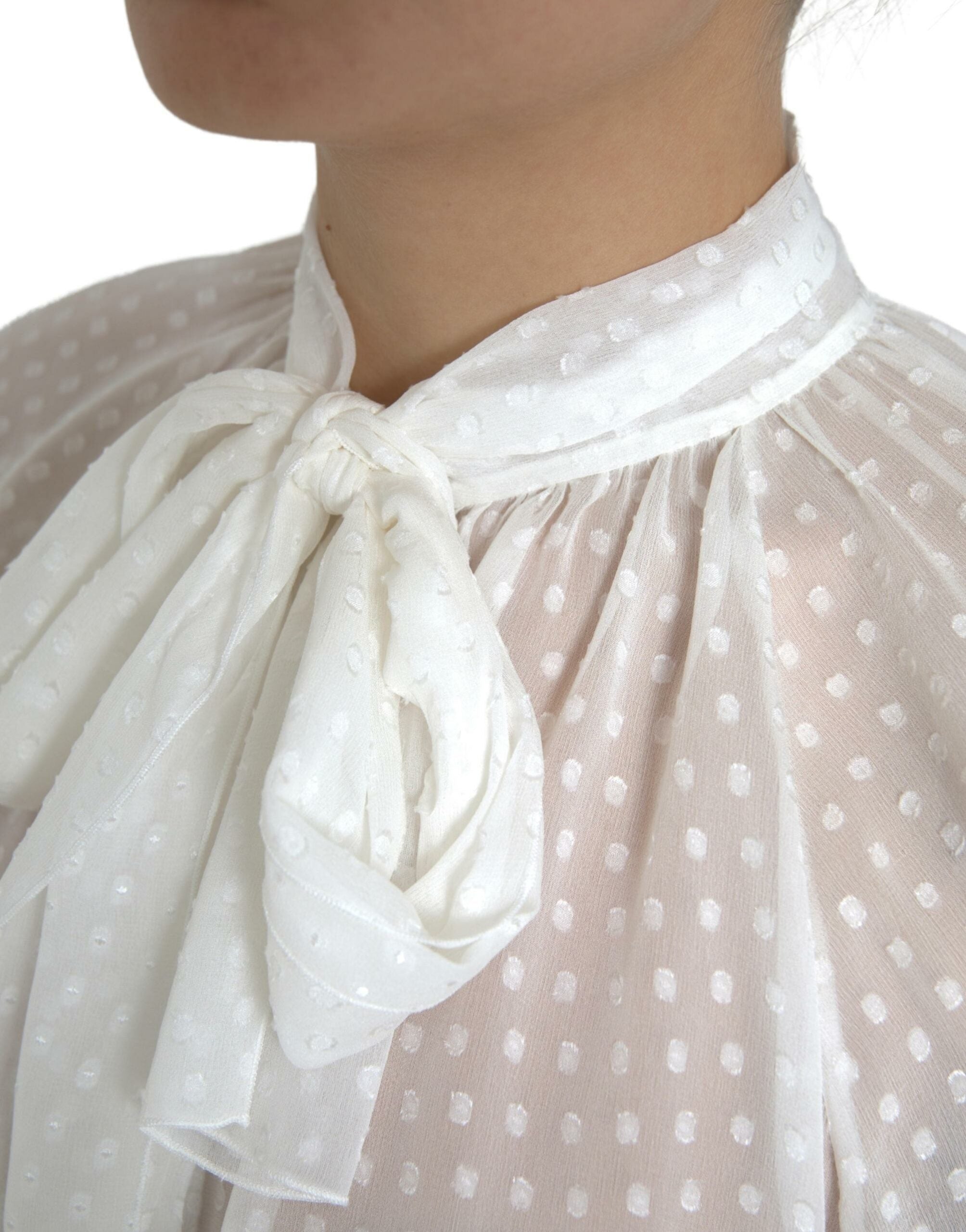 Blouse en soie blanche Dolce & Gabbana à pois, transparente avec nœud au cou, style élégant et sophistiqué.