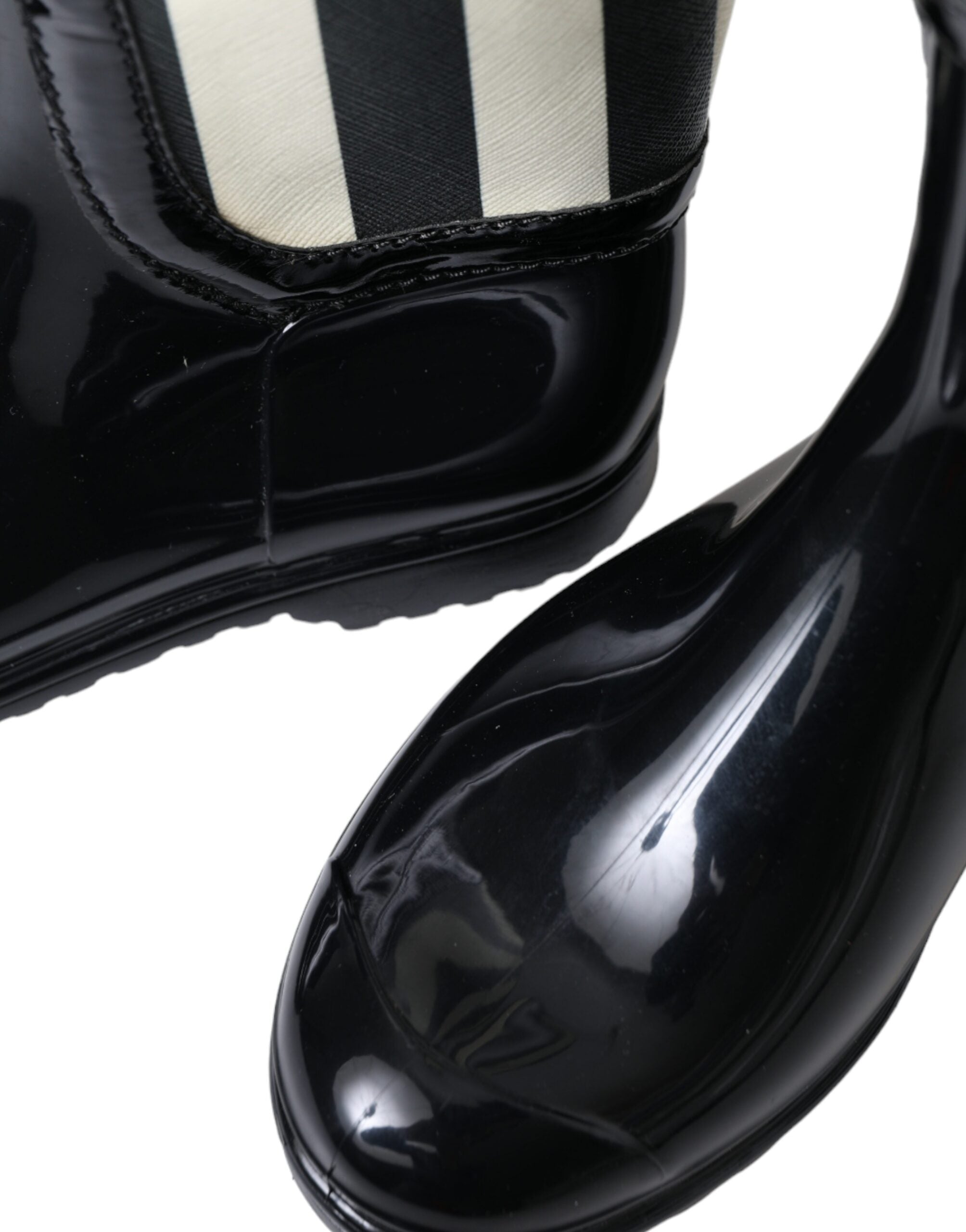 Bottes plates en caoutchouc noir Dolce & Gabbana, hautes jusqu’au genou, avec semelle plate et design élégant.