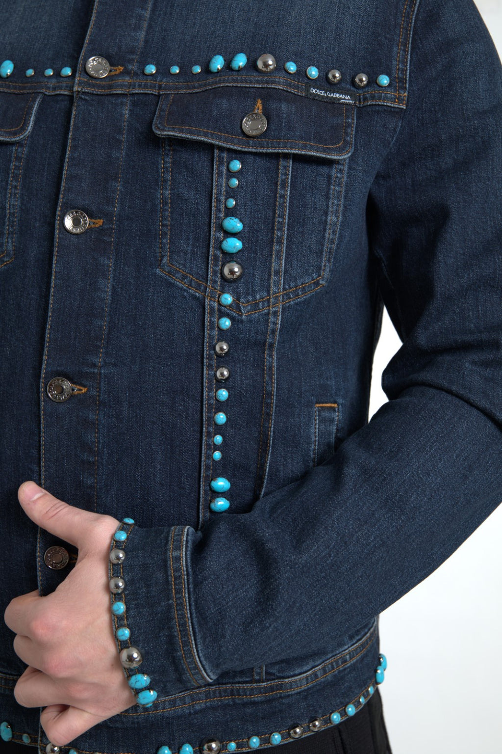 Veste en denim bleu Dolce & Gabbana avec pierres turquoise et studs, style tendance et détails ornementaux.