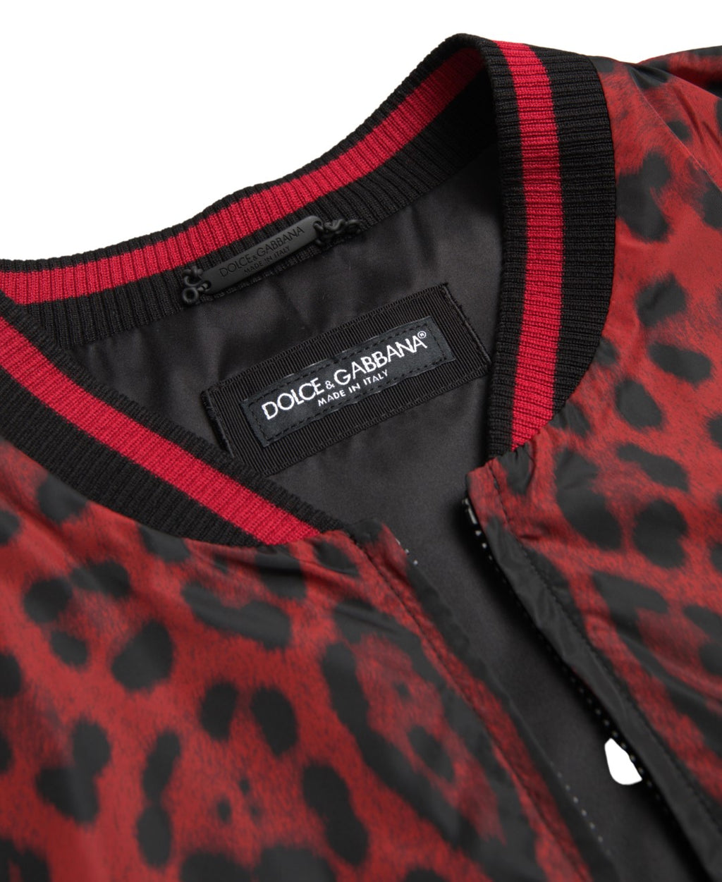Veste courte en daim rouge à motif léopard de Dolce & Gabbana, bomber chic avec col et poches visibles.