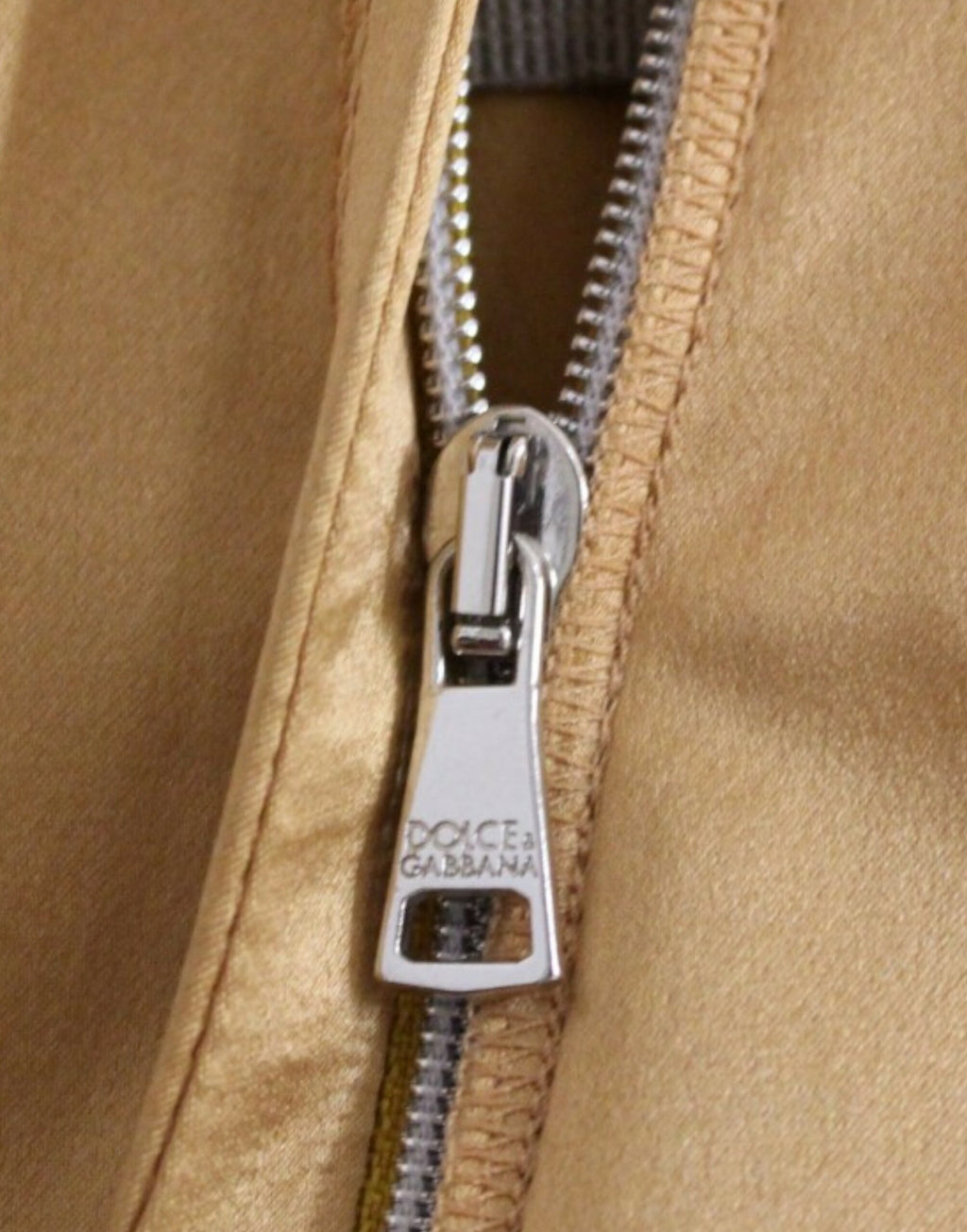 Robe en soie bronze de style fourreau Dolce & Gabbana, ajustée et élégante, visible dans l'image.