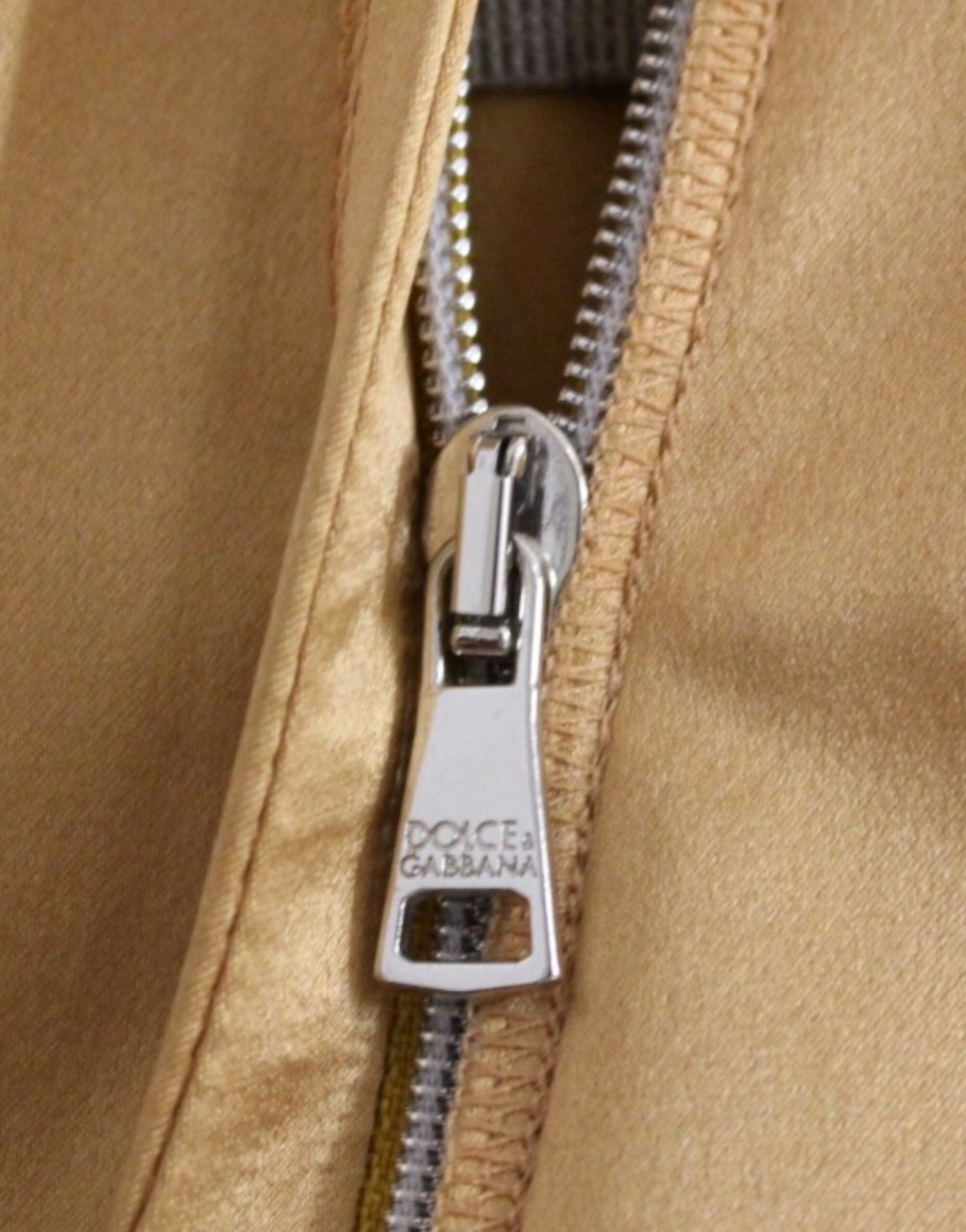 Robe en soie bronze de style fourreau Dolce & Gabbana, ajustée et élégante, visible dans l'image.