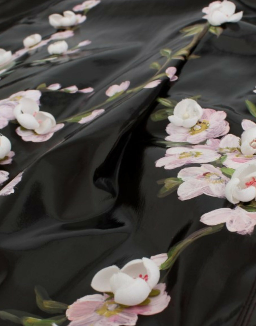 Robe noire en cuir verni avec motifs floraux peints à la main par Dolce & Gabbana, style élégant et sophistiqué.