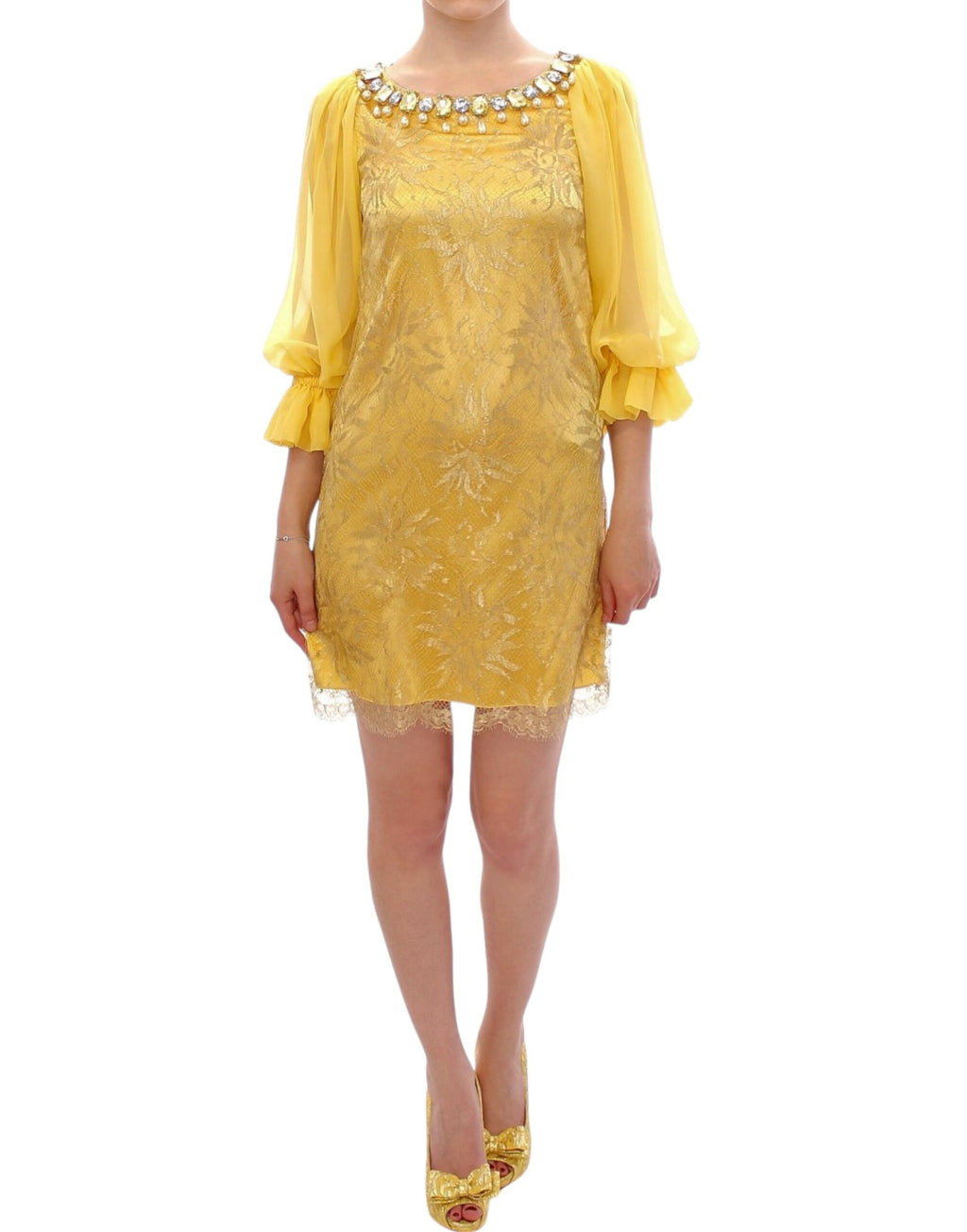 Robe courte en dentelle jaune avec cristaux de Dolce & Gabbana, détail élégant et sophistiqué, portée sur un mannequin.