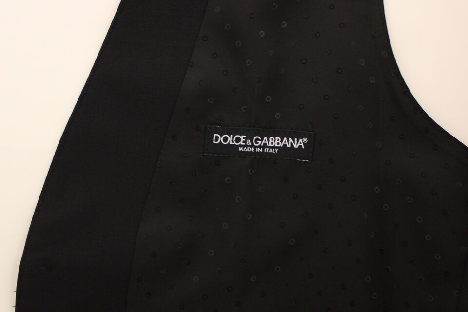 Gilet blazer en laine et soie noire de Dolce & Gabbana, coupe ajustée, avec col et détails élégants sur fond neutre.