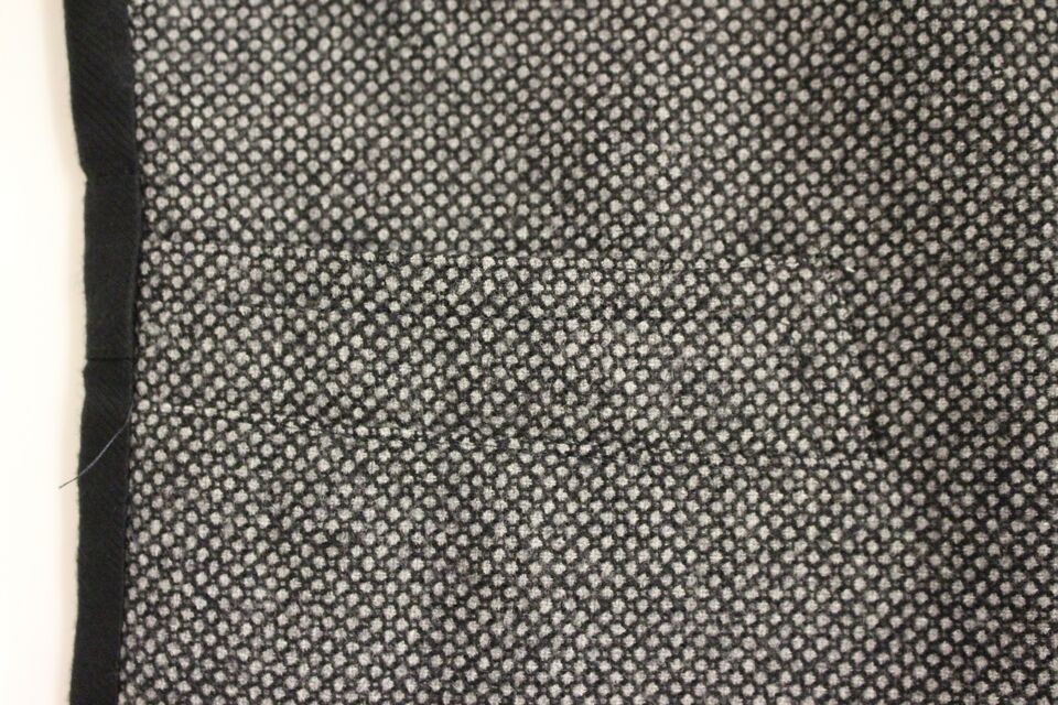Gilet en coton mélangé gris Dolce & Gabbana avec logo, porté sur un mannequin, détails de la texture et coupe modernes.