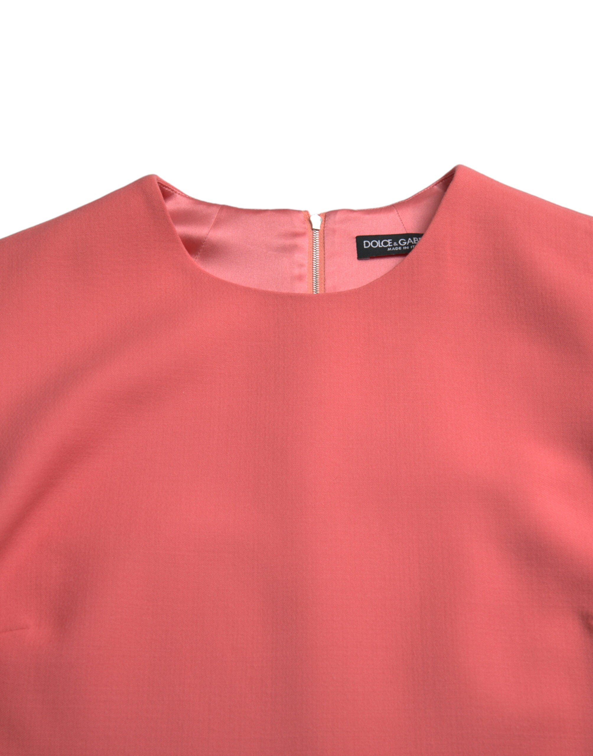 Robe courte en laine vierge rose sans manches de Dolce & Gabbana, élégante et tendance, portée sur un fond neutre.