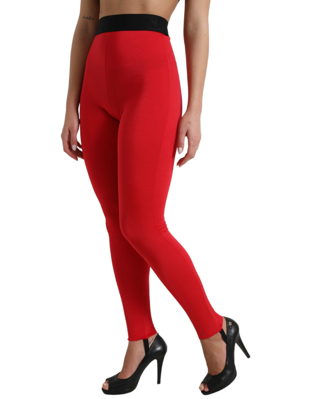 Leggings slim en nylon rouge Dolce & Gabbana avec logo DG, ajustés et tendance, visibles sur un fond neutre.