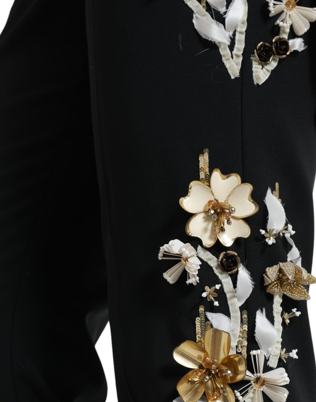 Pantalon tapered noir Dolce & Gabbana avec appliqué floral, taille haute et design élégant, visible en gros plan.