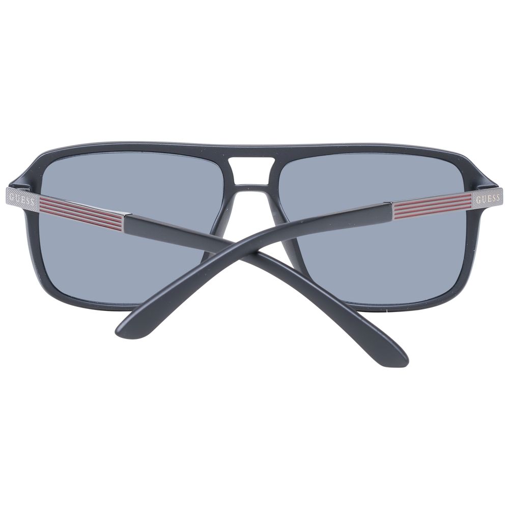 Lunettes de soleil en plastique noir Guess avec monture élégante et branches épaisses, mode et protection solaire.