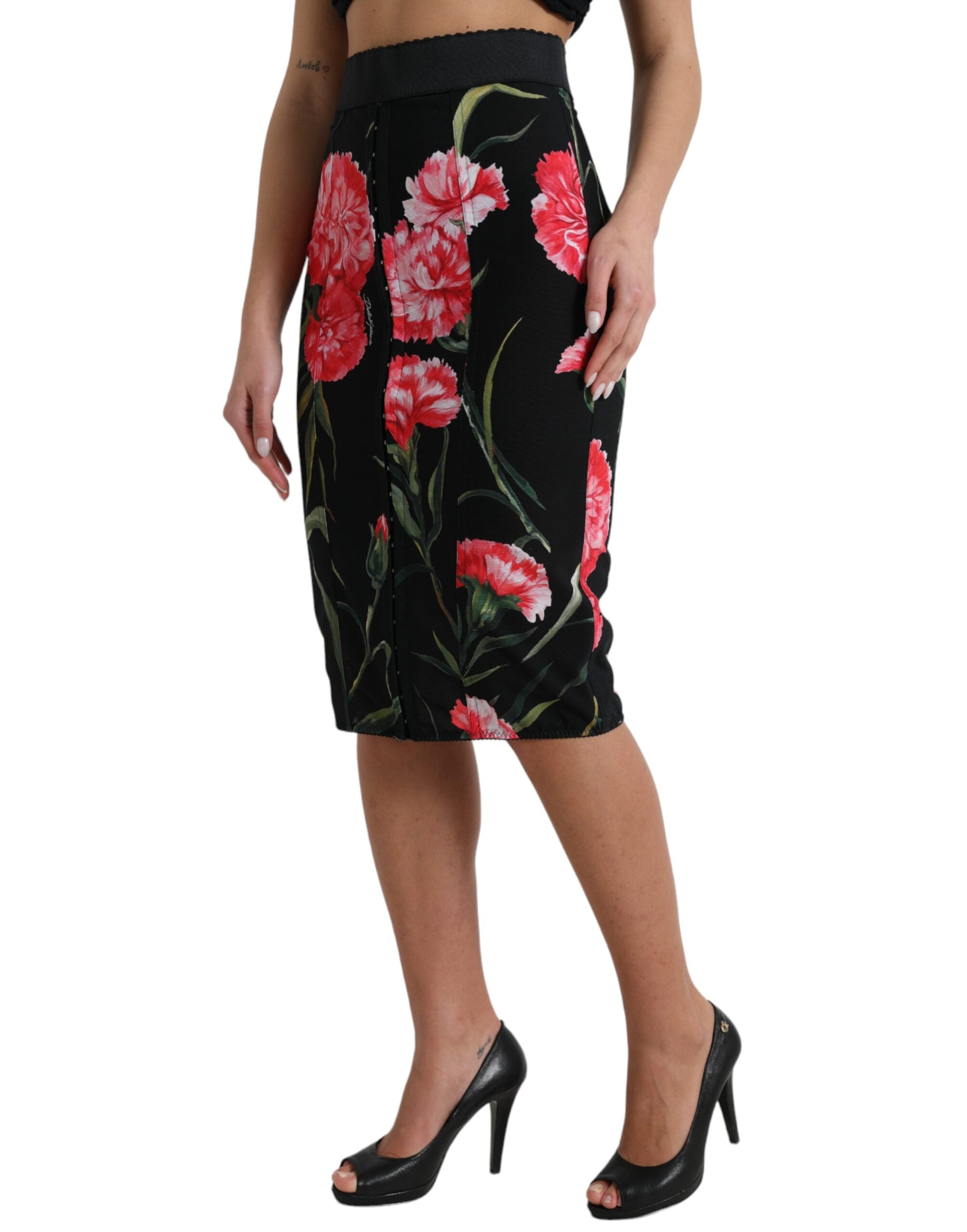 Jupe noire en coupe crayon à longueur genou avec motif de œillets de Carnation, marque Dolce & Gabbana.