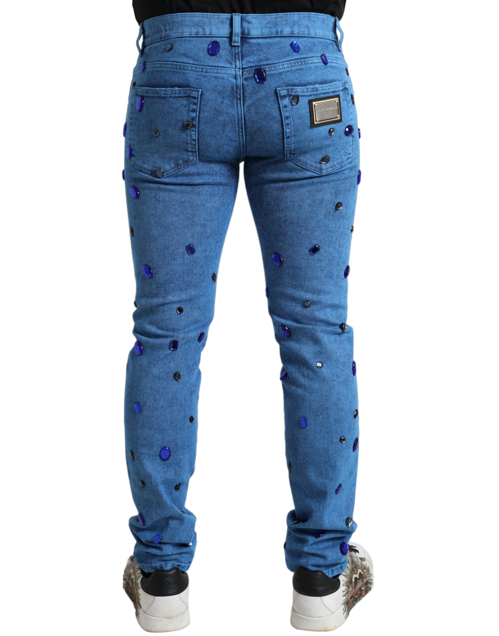 Jeans skinny en denim bleu Dolce & Gabbana ornés de cristaux brillants, style élégant et moderne.