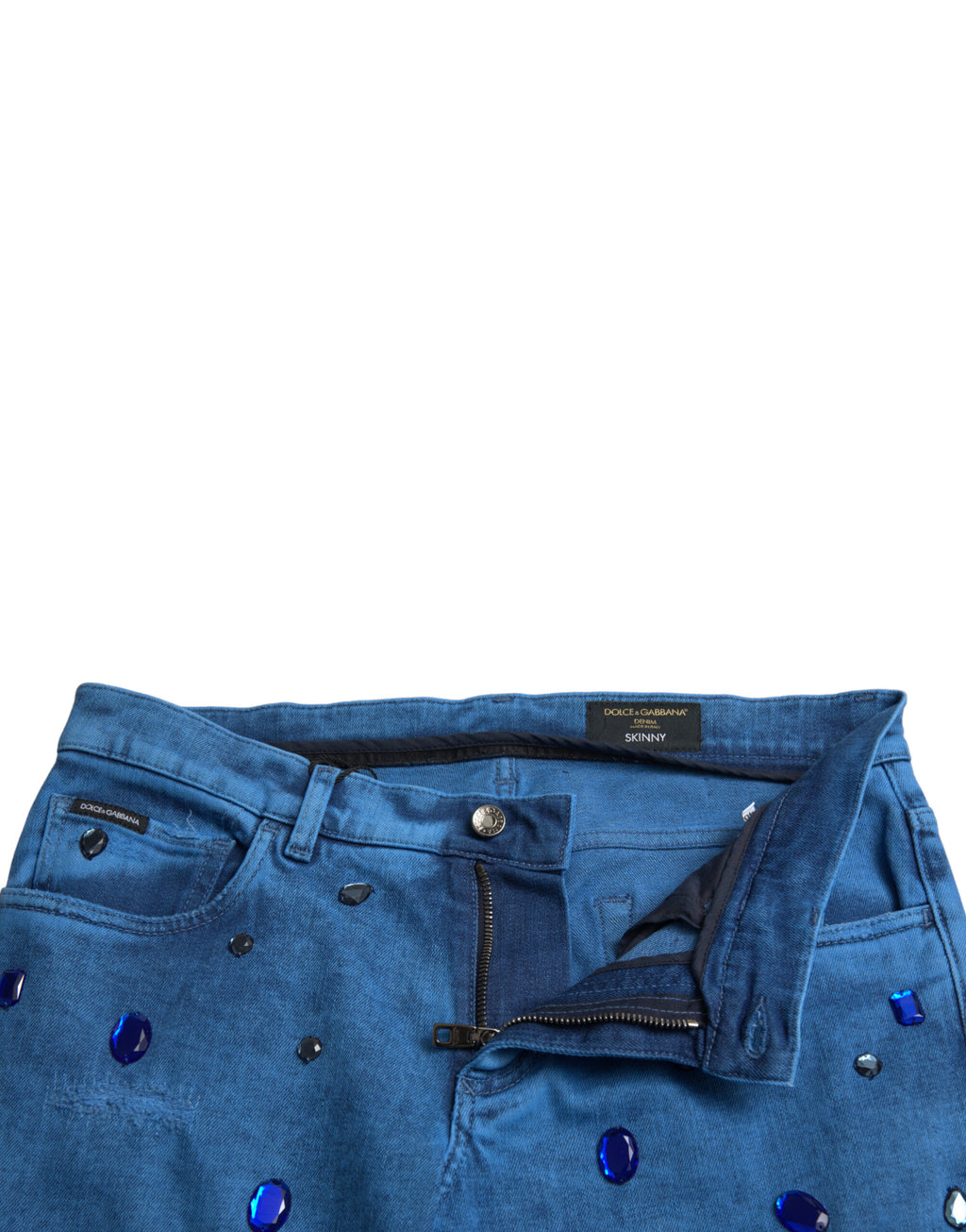 Jeans skinny en denim bleu Dolce & Gabbana ornés de cristaux brillants, mode élégante et sophistiquée.