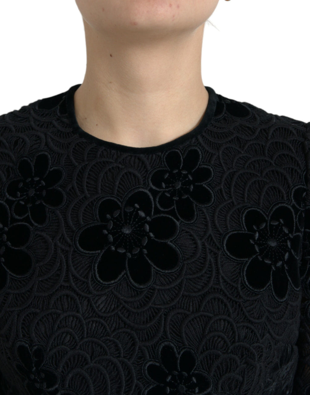 Robe noire Dolce & Gabbana en dentelle florale en coton, coupe bodycon, portée élégante.