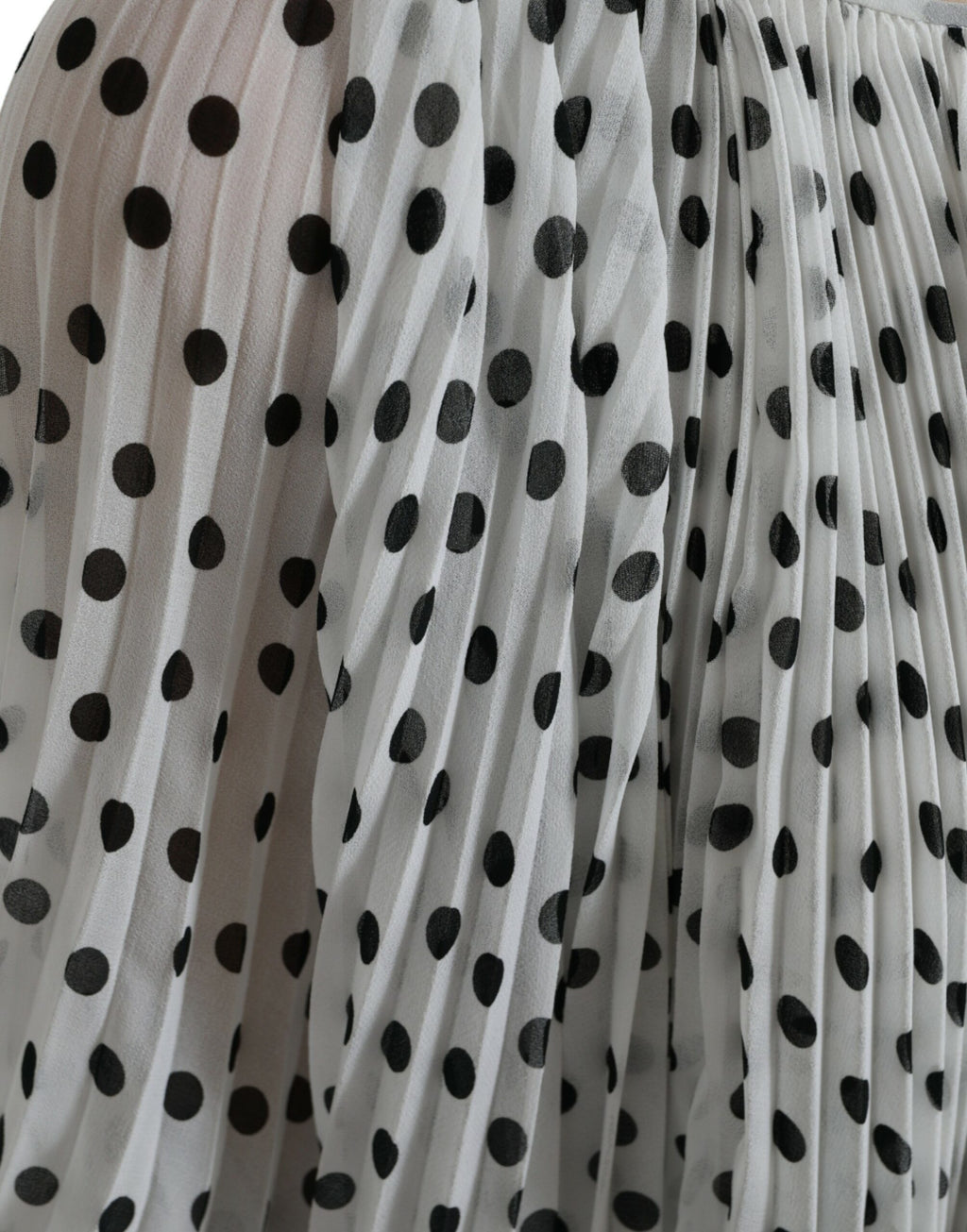 Robe maxi blanche à pois noirs Dolce & Gabbana avec coupe évasée et plis, élégante et fluide.