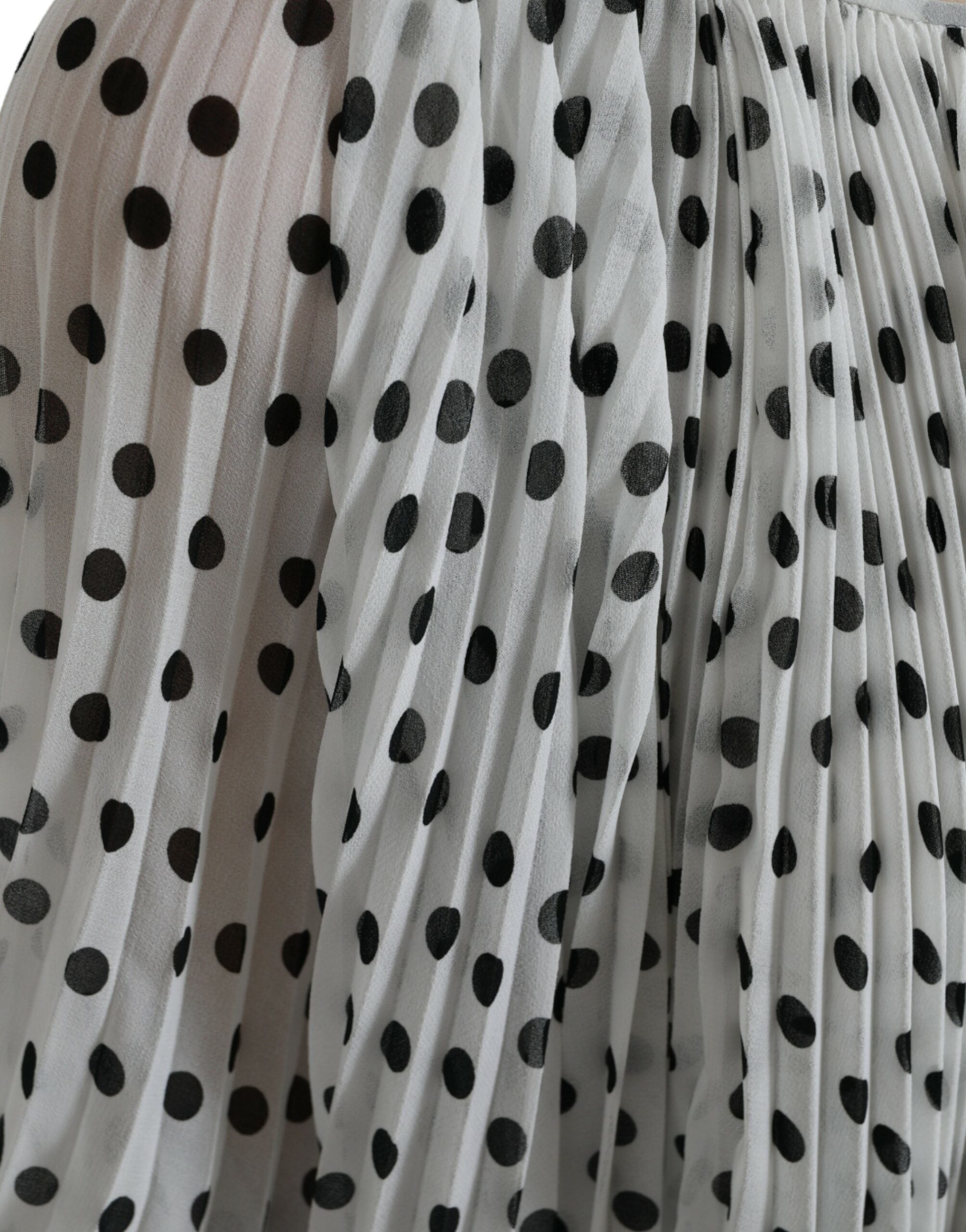 Robe maxi blanche à pois noirs Dolce & Gabbana avec coupe évasée et plis, élégante et fluide.