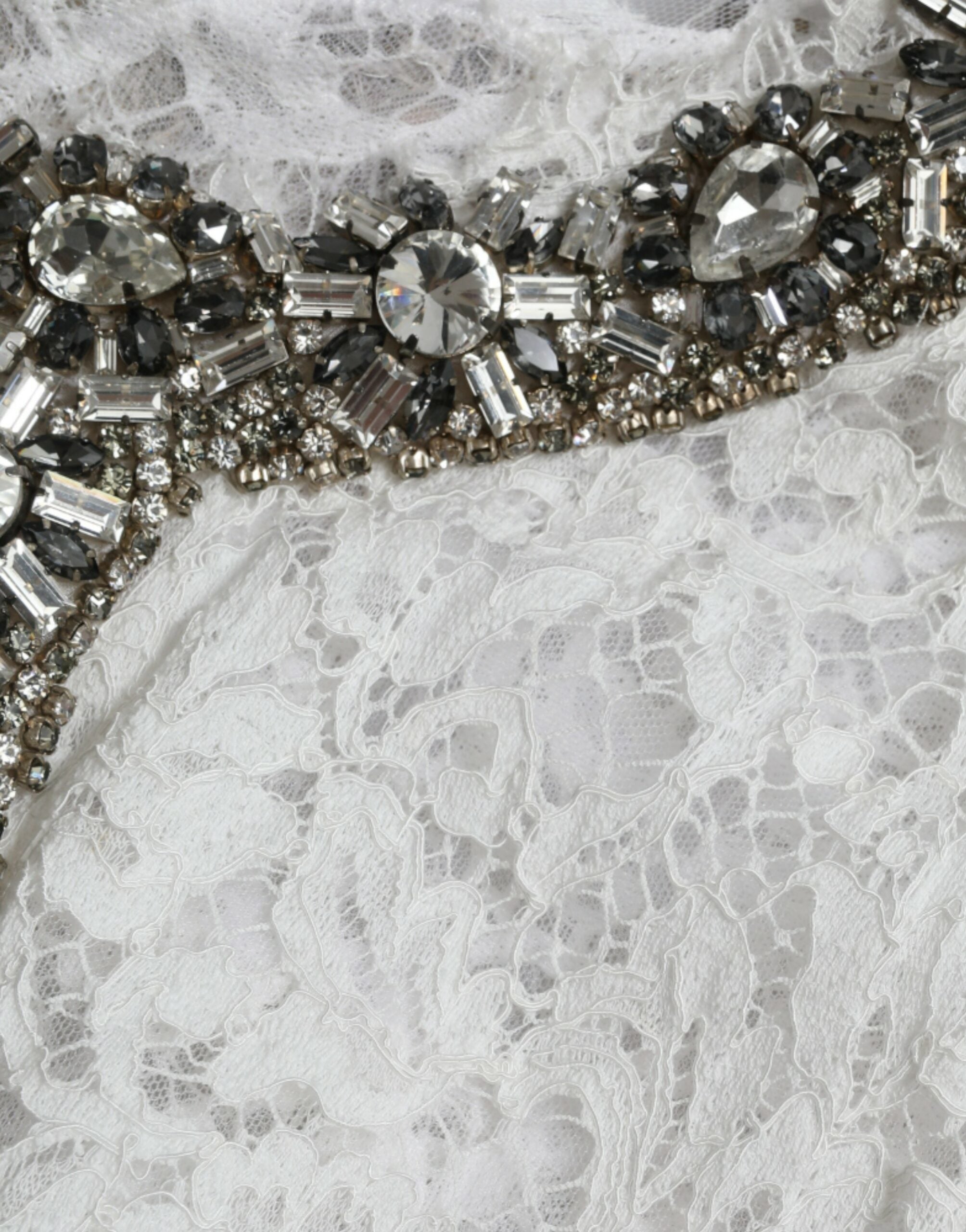 Robe blanche en dentelle Dolce & Gabbana avec cristaux, coupe droite élégante et détails raffinés pour une allure sophistiquée.