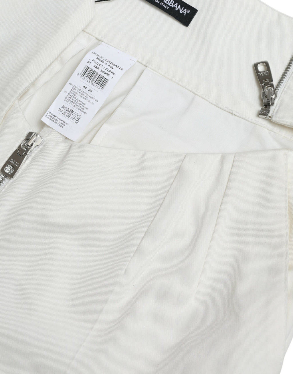 Pantalons taperés noirs et blancs en coton avec découpe à la taille, de la marque Dolce & Gabbana, visibles en image.