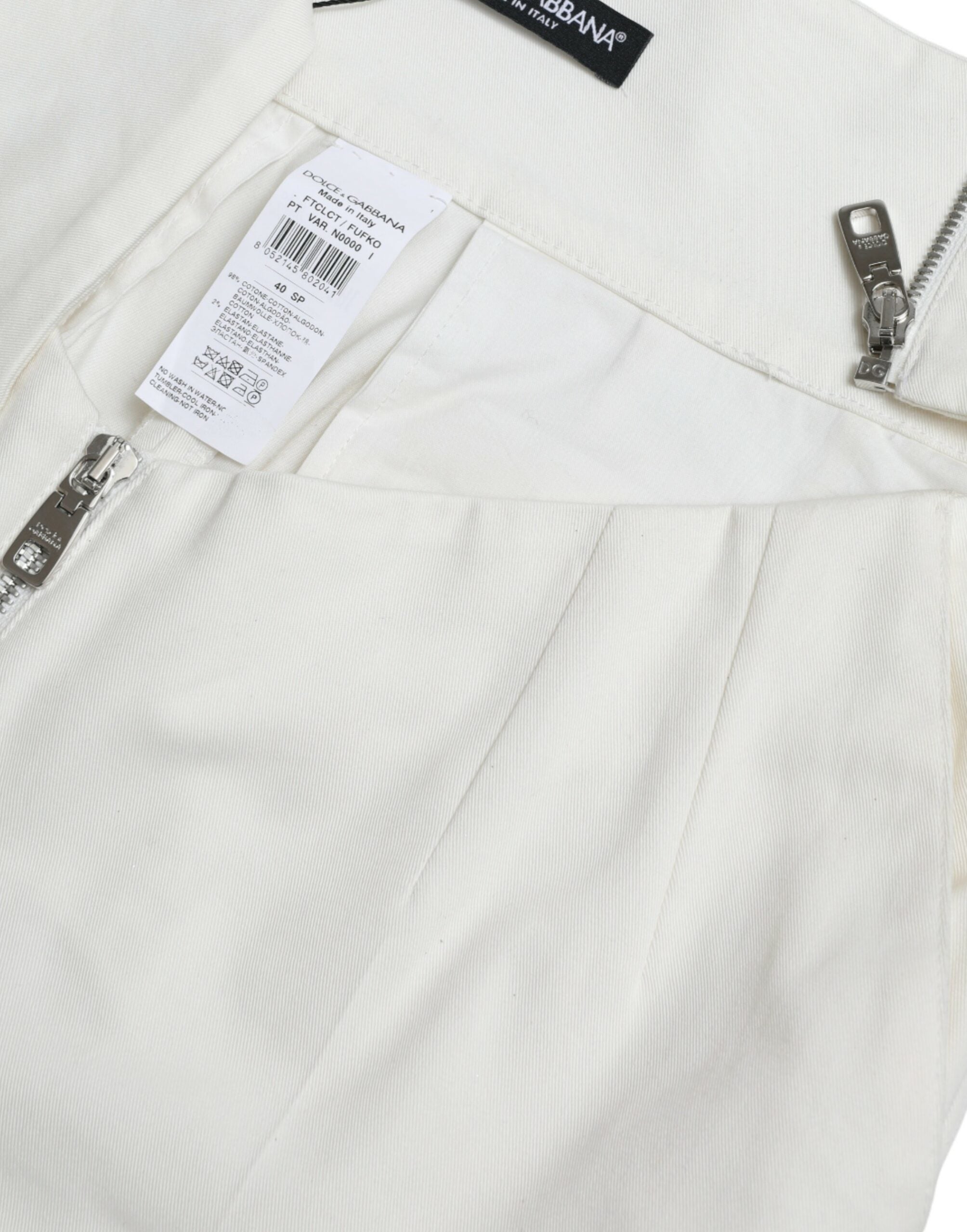 Pantalons taperés noirs et blancs en coton avec découpe à la taille, de la marque Dolce & Gabbana, visibles en image.