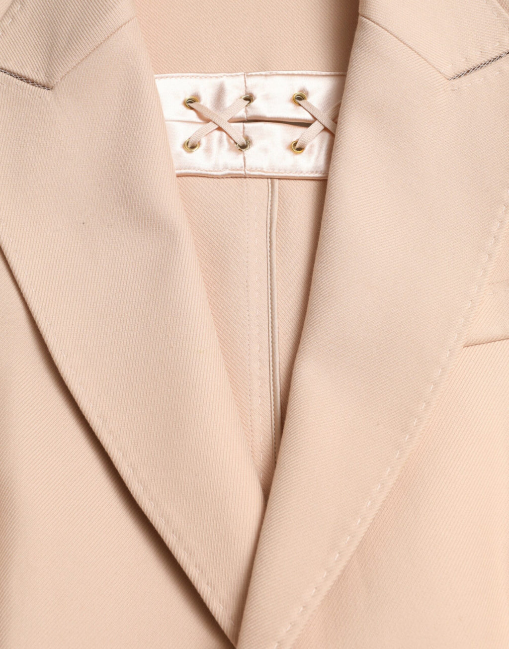 Manteau beige en coton Dolce & Gabbana, à double boutonnage, long et élégant, porté sur un mannequin.