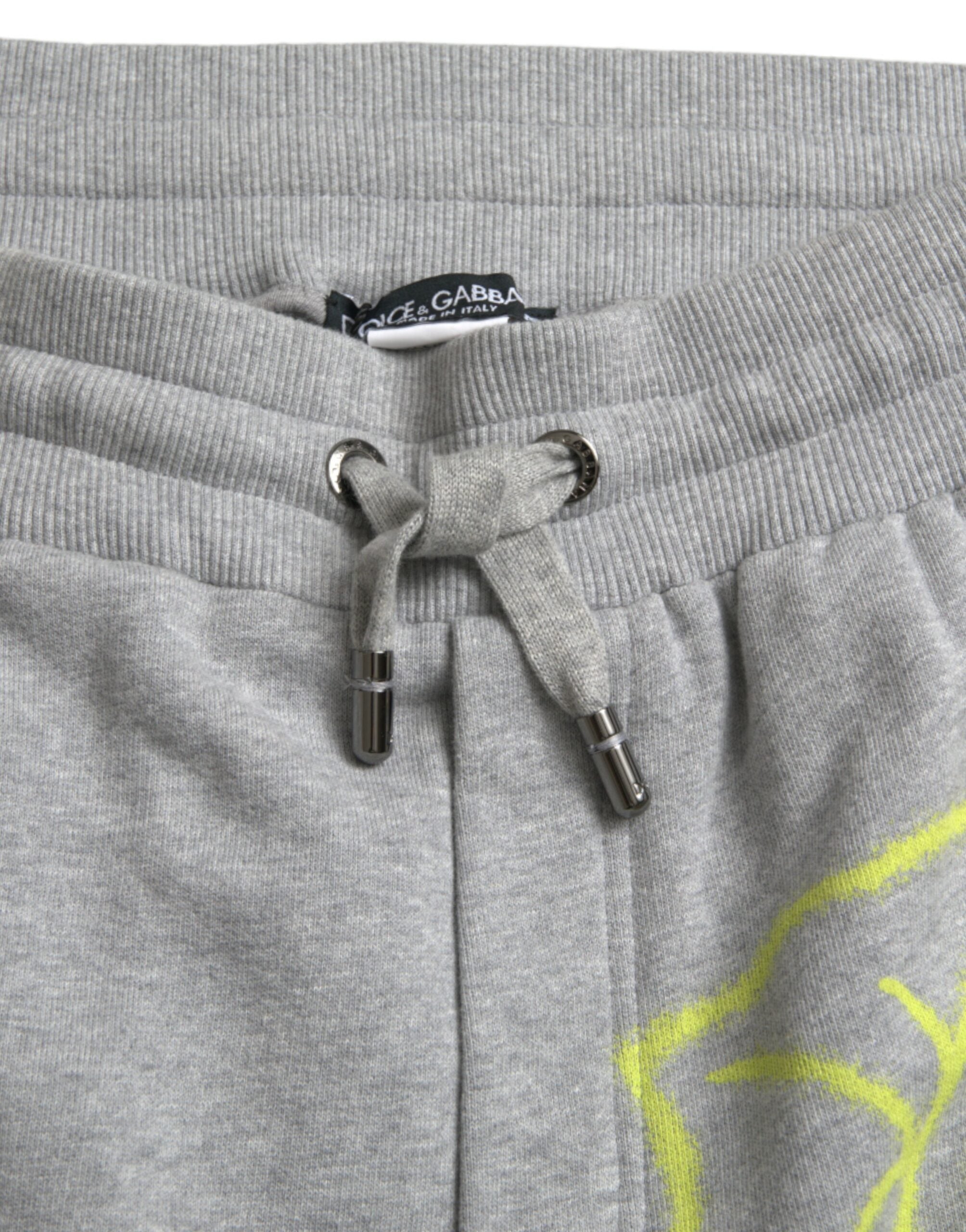 Pantalon jogger Dolce & Gabbana en coton gris avec motif graffiti, style décontracté et confortable.