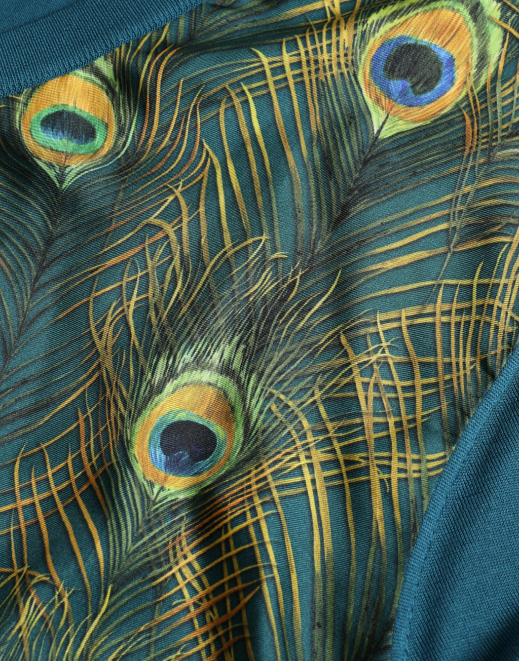 Pull Dolce & Gabbana en maille vert avec motif de plumes de paon, doux et élégant, visible sur l'image.