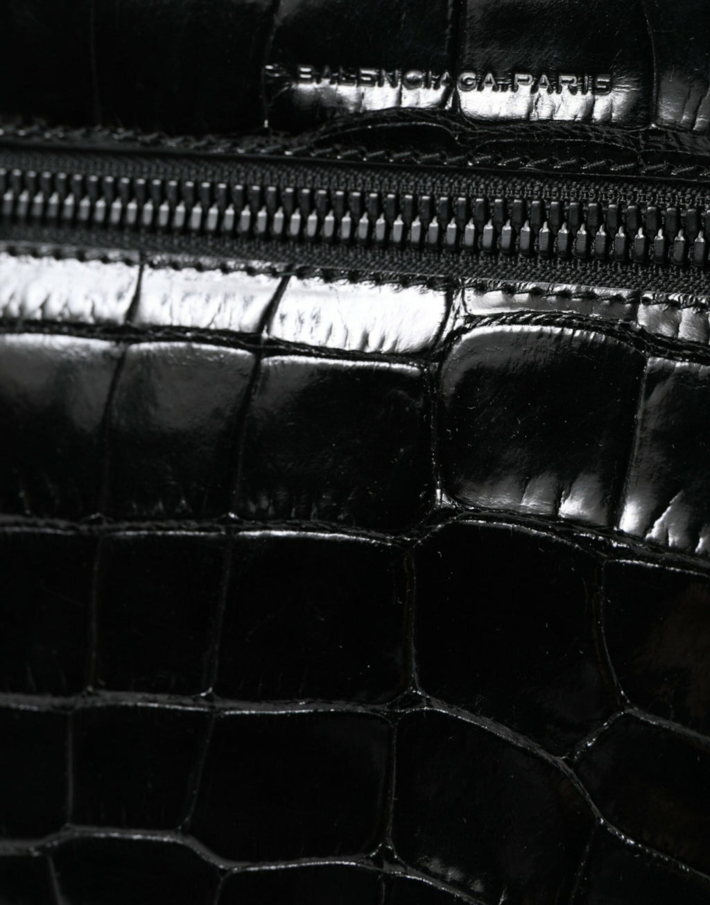 Sac à bandoulière Balenciaga en cuir exotique noir, style sac photo avec poches et design élégant visible sur l'image.