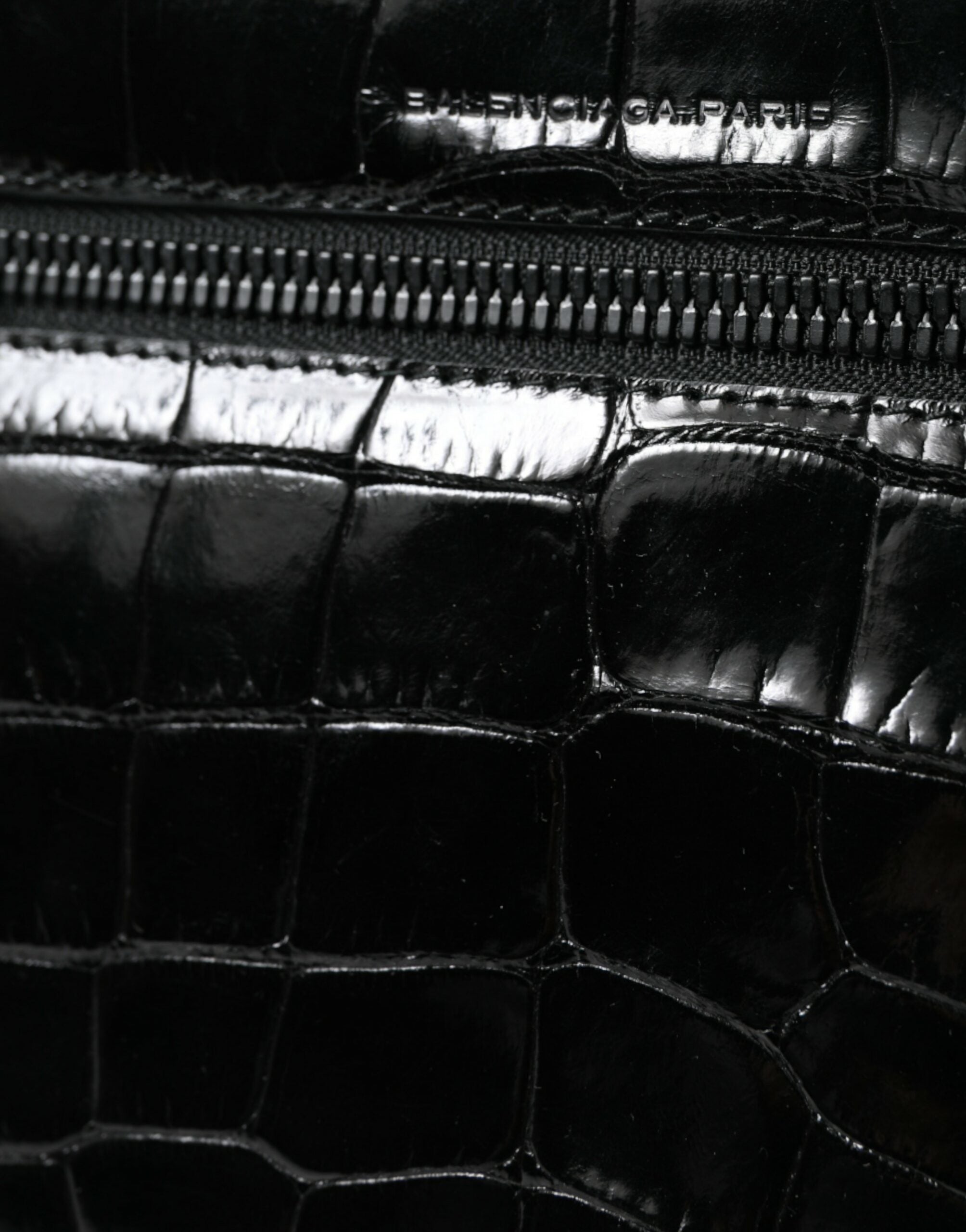 Sac à bandoulière Balenciaga en cuir exotique noir, style sac photo avec poches et design élégant visible sur l'image.