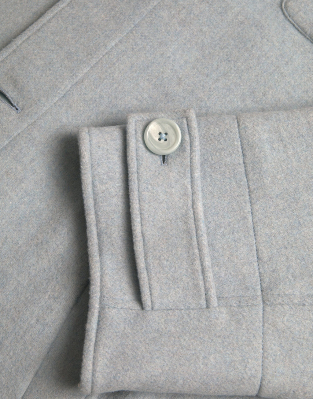 Manteau trench en laine bleu clair de Dolce & Gabbana Light Blue avec boutons, porté sur un mannequin.