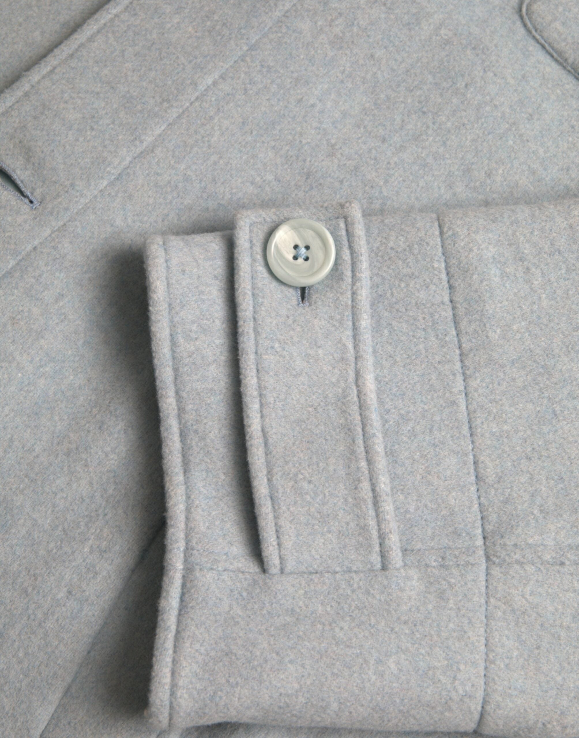 Manteau trench en laine bleu clair de Dolce & Gabbana Light Blue avec boutons, porté sur un mannequin.