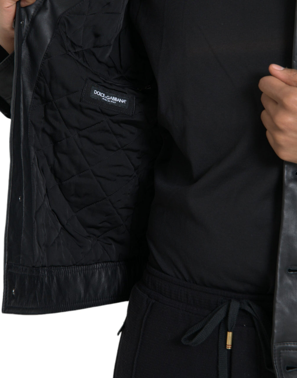 Manteau biker en cuir noir Dolce & Gabbana avec col en fourrure, style élégant et sophistiqué pour femmes ou hommes.