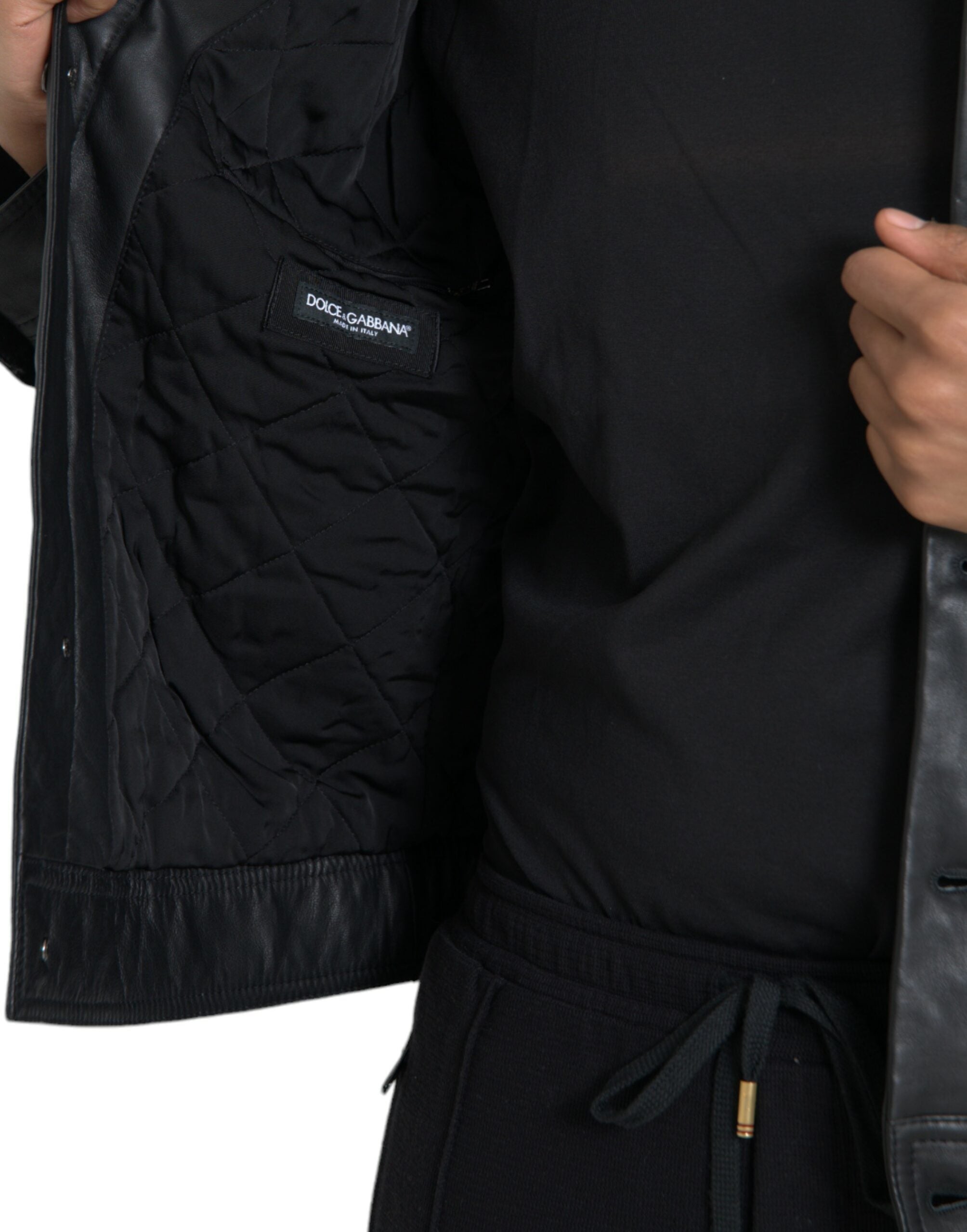 Manteau biker en cuir noir Dolce & Gabbana avec col en fourrure, style élégant et sophistiqué pour femmes ou hommes.