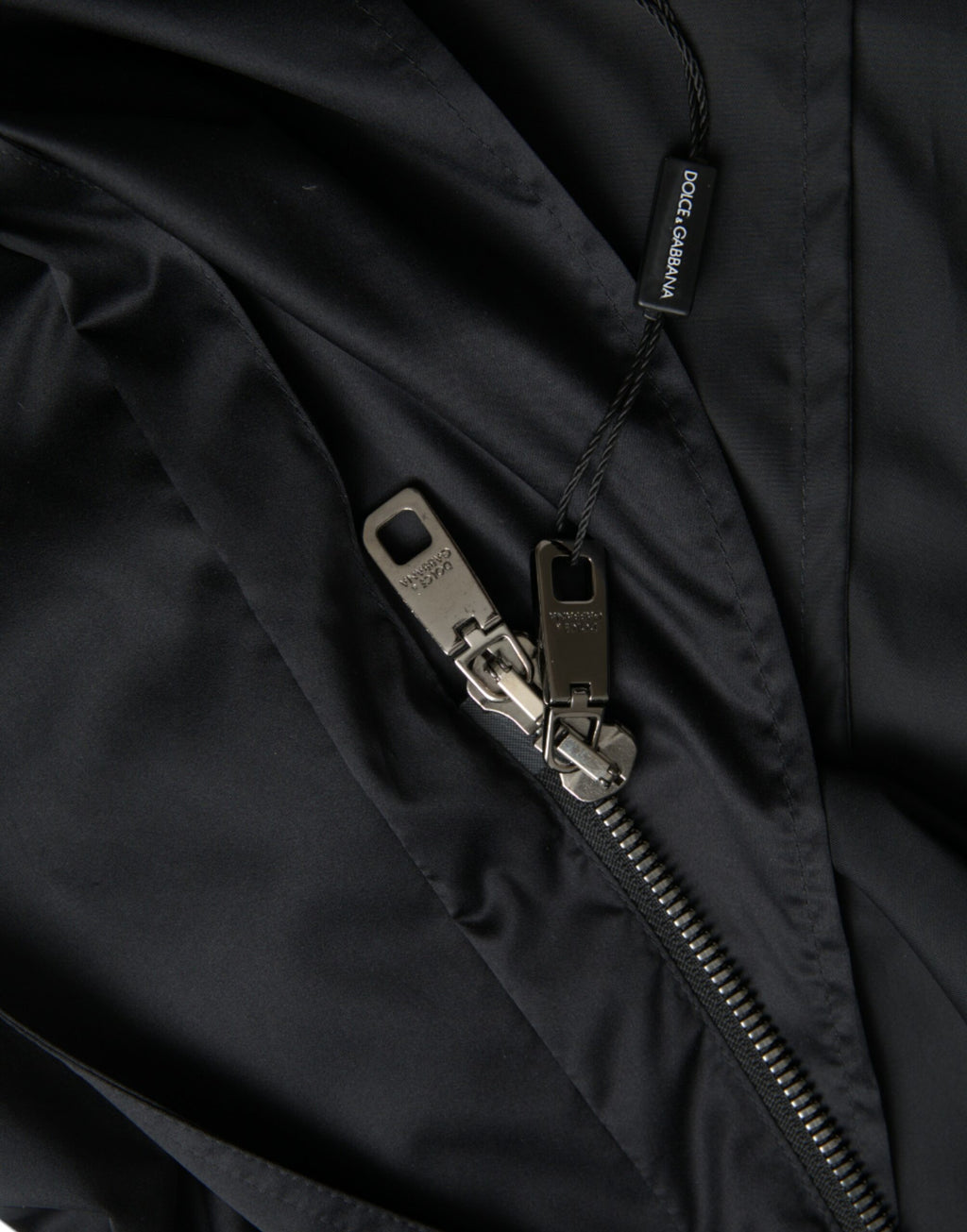 Veste longue coupe-vent noire en polyester avec capuche de la marque Dolce & Gabbana, détails modernes et style urbain