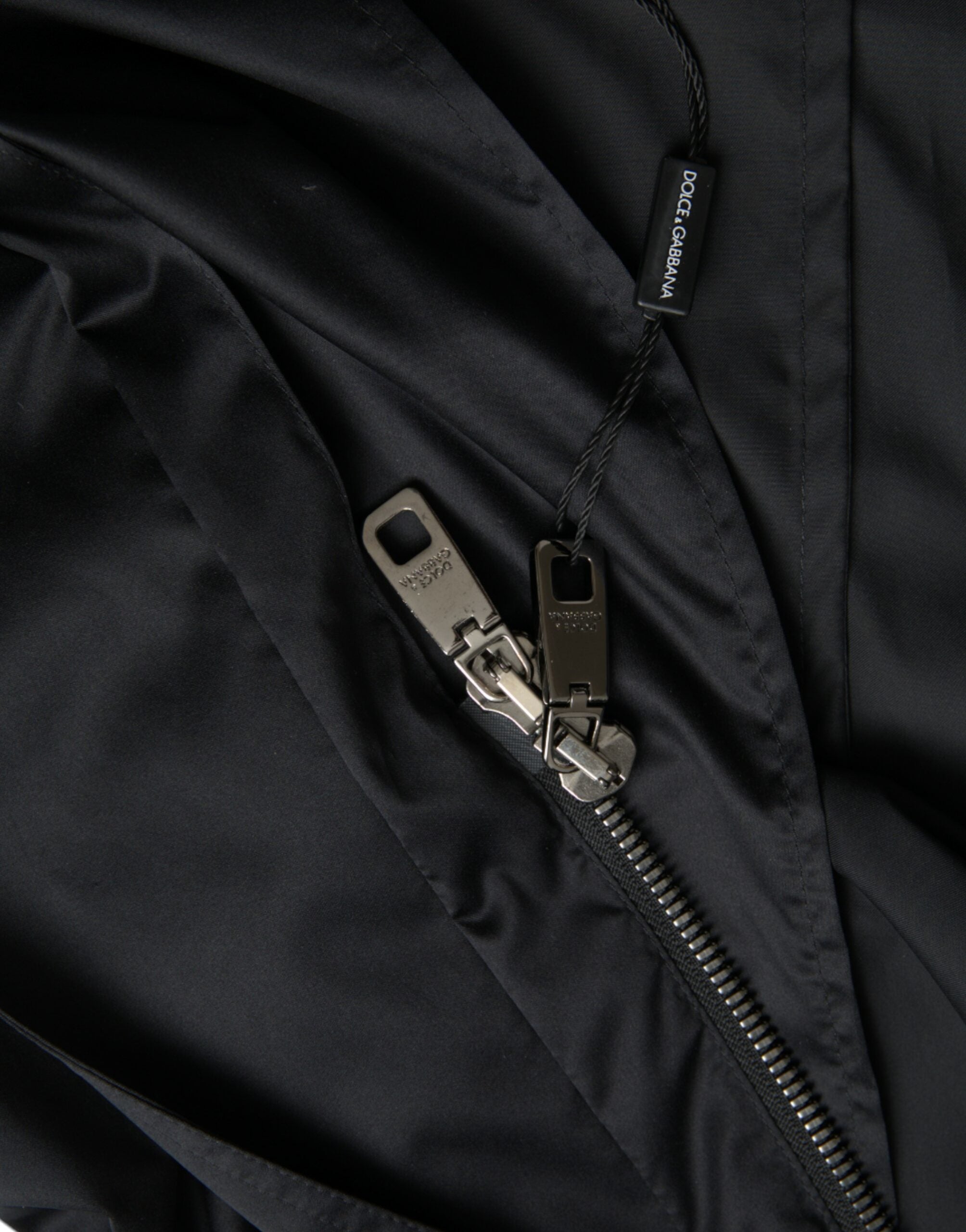 Veste longue coupe-vent noire en polyester avec capuche de la marque Dolce & Gabbana, détails modernes et style urbain