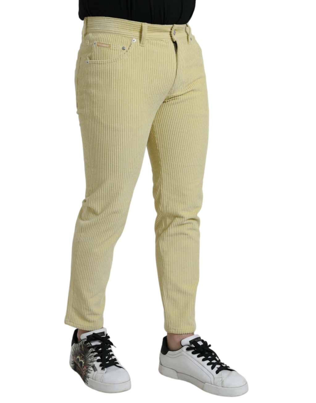 Jeans slim en denim jaune Dolce & Gabbana avec logo en plaque en velours côtelé, visible détails de la coupe et de la texture.