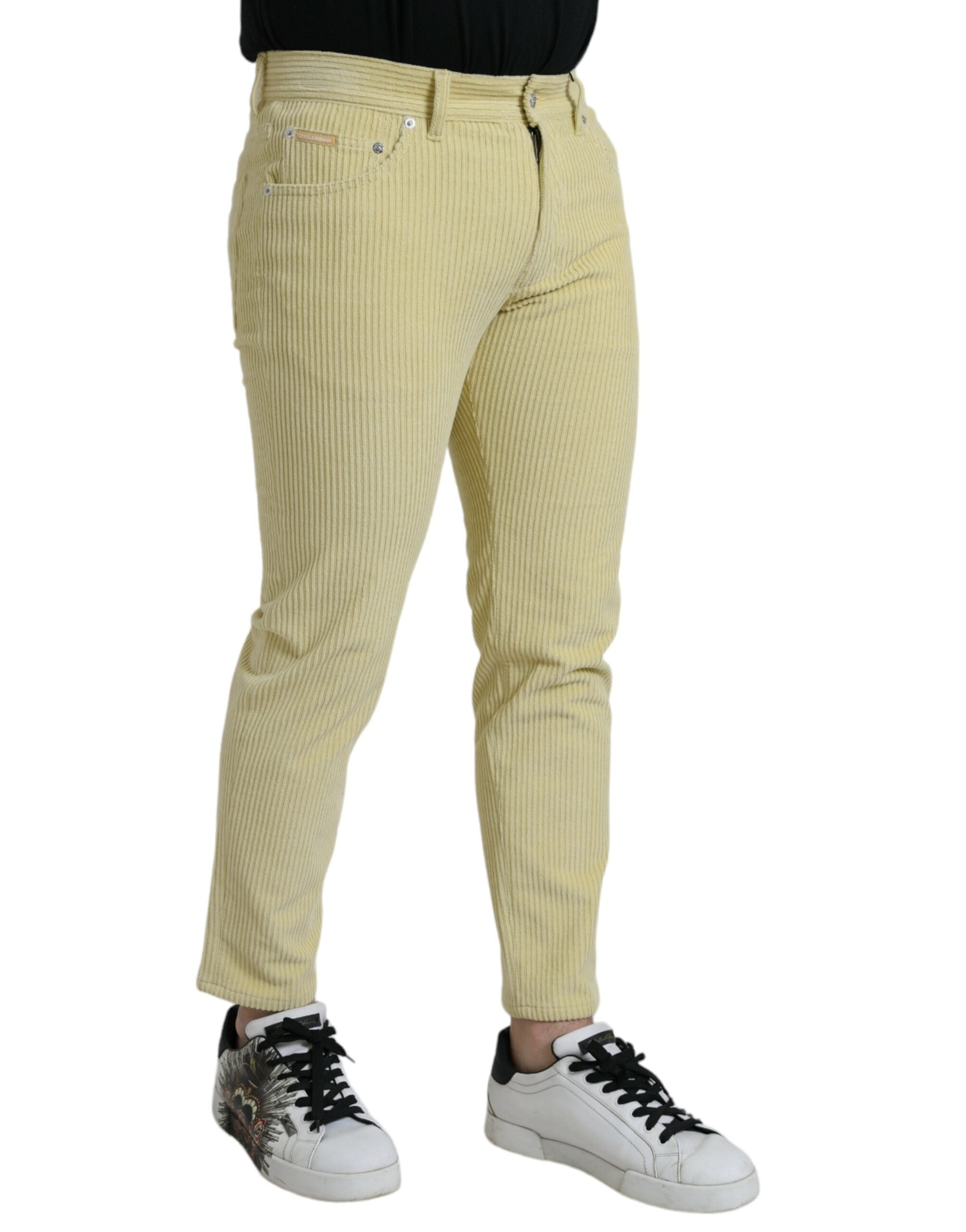 Jeans slim en denim jaune Dolce & Gabbana avec logo en plaque en velours côtelé, visible détails de la coupe et de la texture.