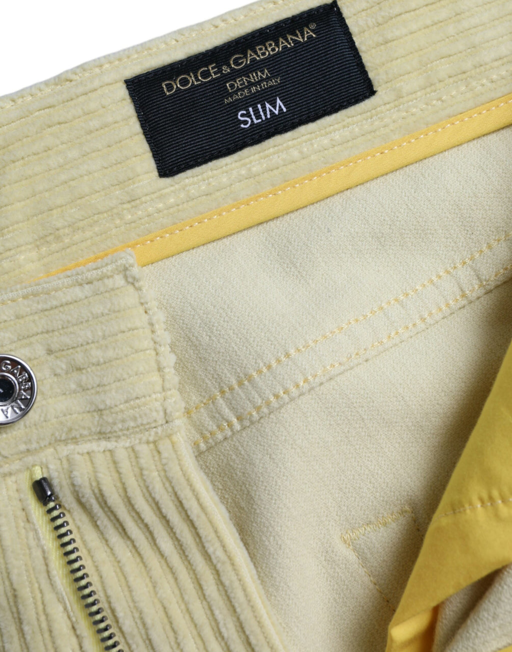 Jeans skinny en denim jaune Dolce & Gabbana avec logo en plaque de velours côtelé, détails élégants et coupe ajustée.