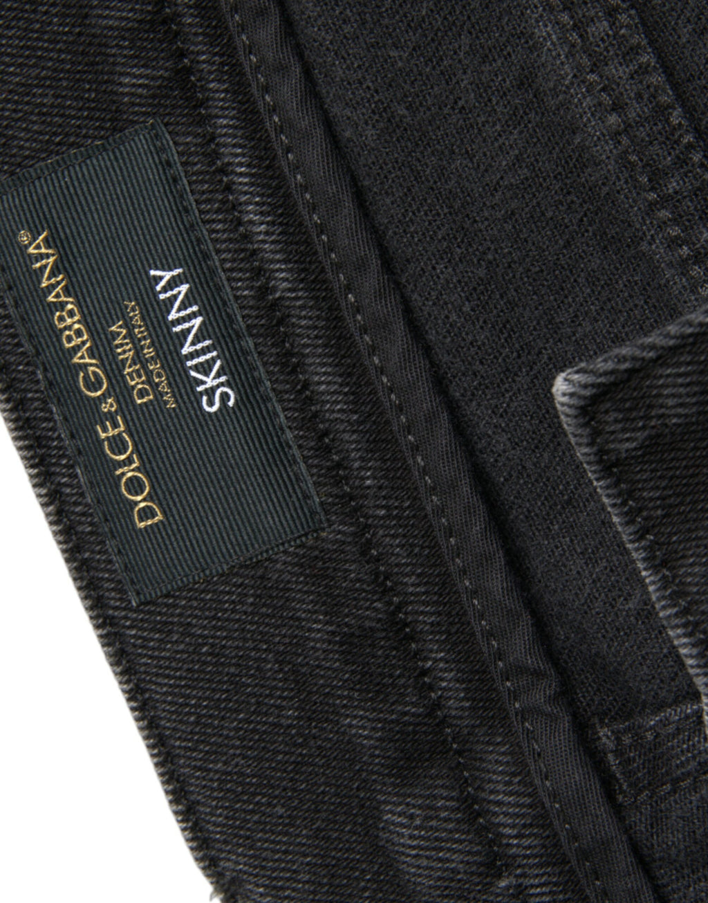 Jeans skinny en denim gris Dolce & Gabbana en coton stretch avec logo, montrant la coupe ajustée et la texture du tissu.