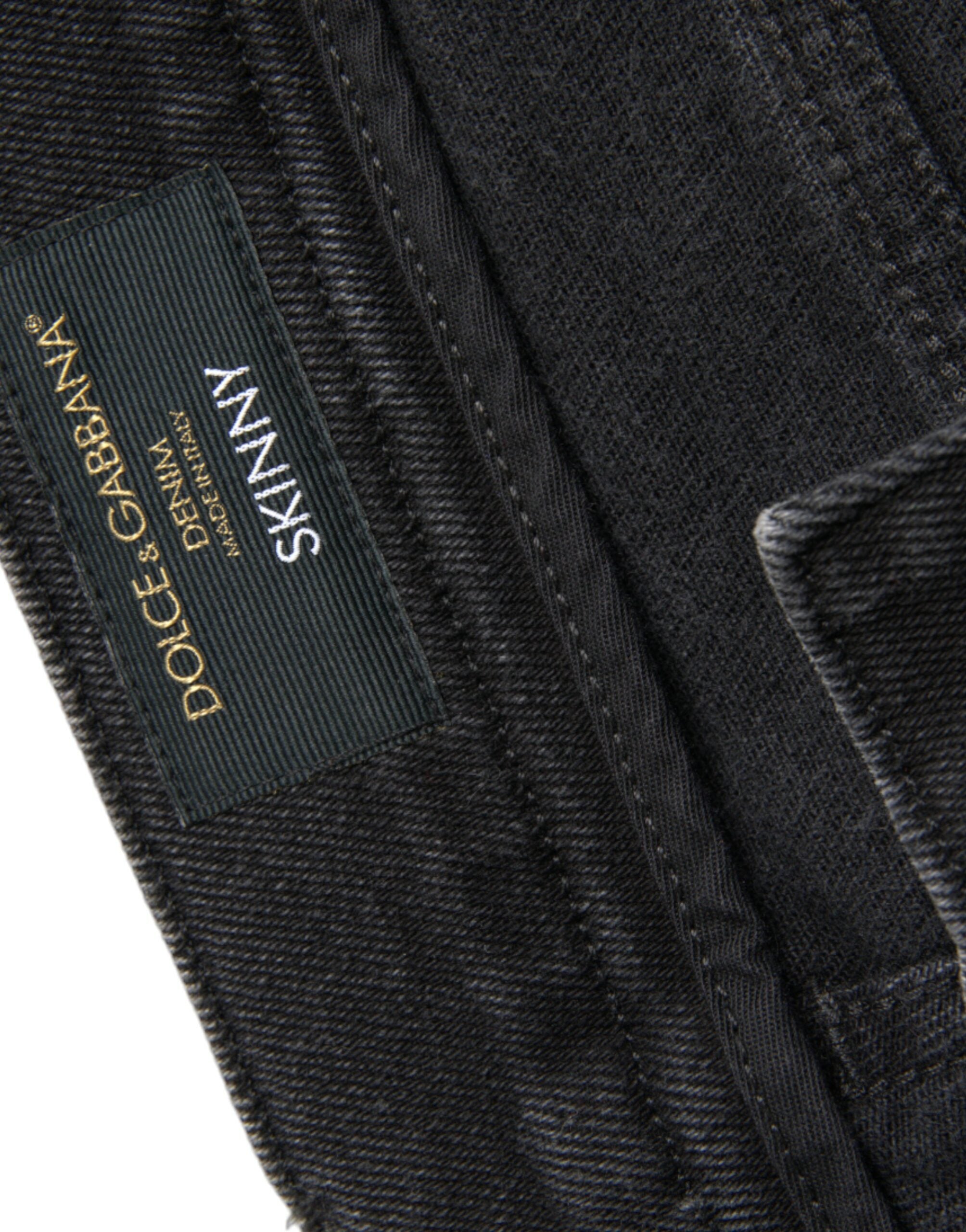 Jeans skinny en denim gris Dolce & Gabbana en coton stretch avec logo, montrant la coupe ajustée et la texture du tissu.