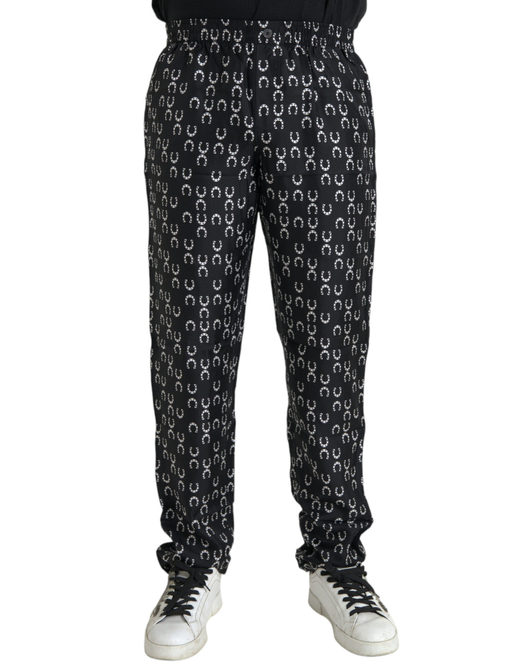 Pantalons en soie noirs à motif fer à cheval Dolce & Gabbana, élégants et sophistiqués, visibles en gros plan.