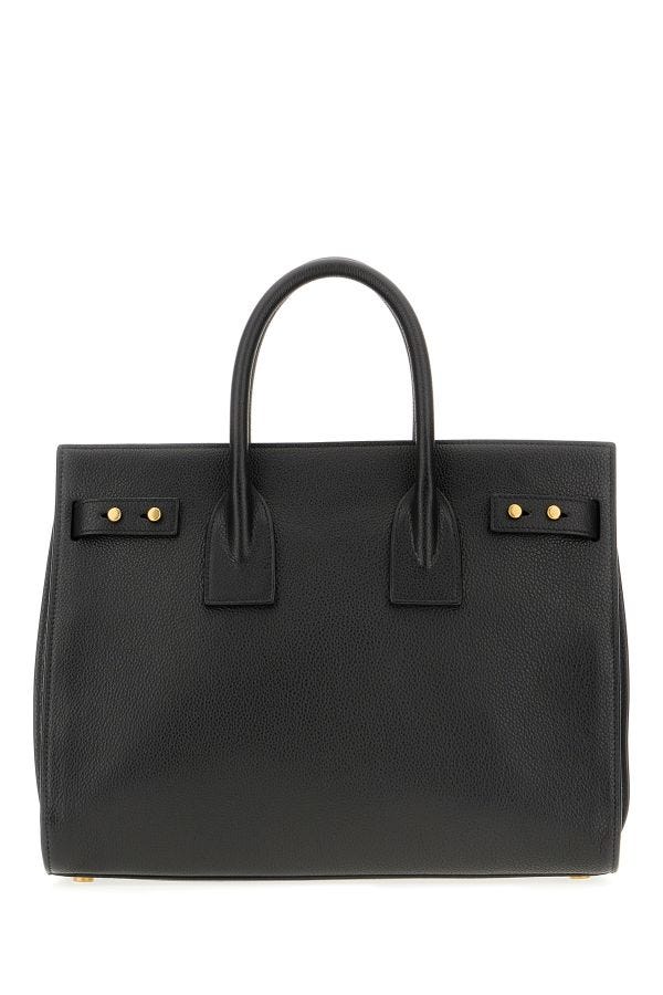 Sac à main Saint Laurent Sac De Jour en cuir de veau noir, élégant et sophistiqué, visible avec ses poignées et détails en cuir.