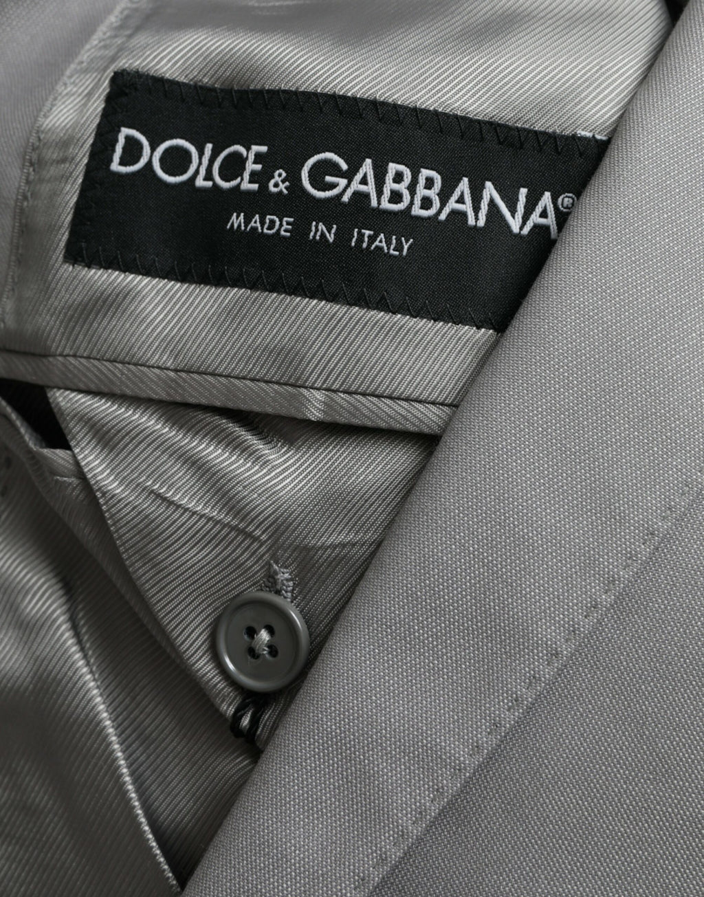 Manteau gris en laine Dolce & Gabbana, blazer à boutonnière simple, coupe élégante, détails sophistiqués.