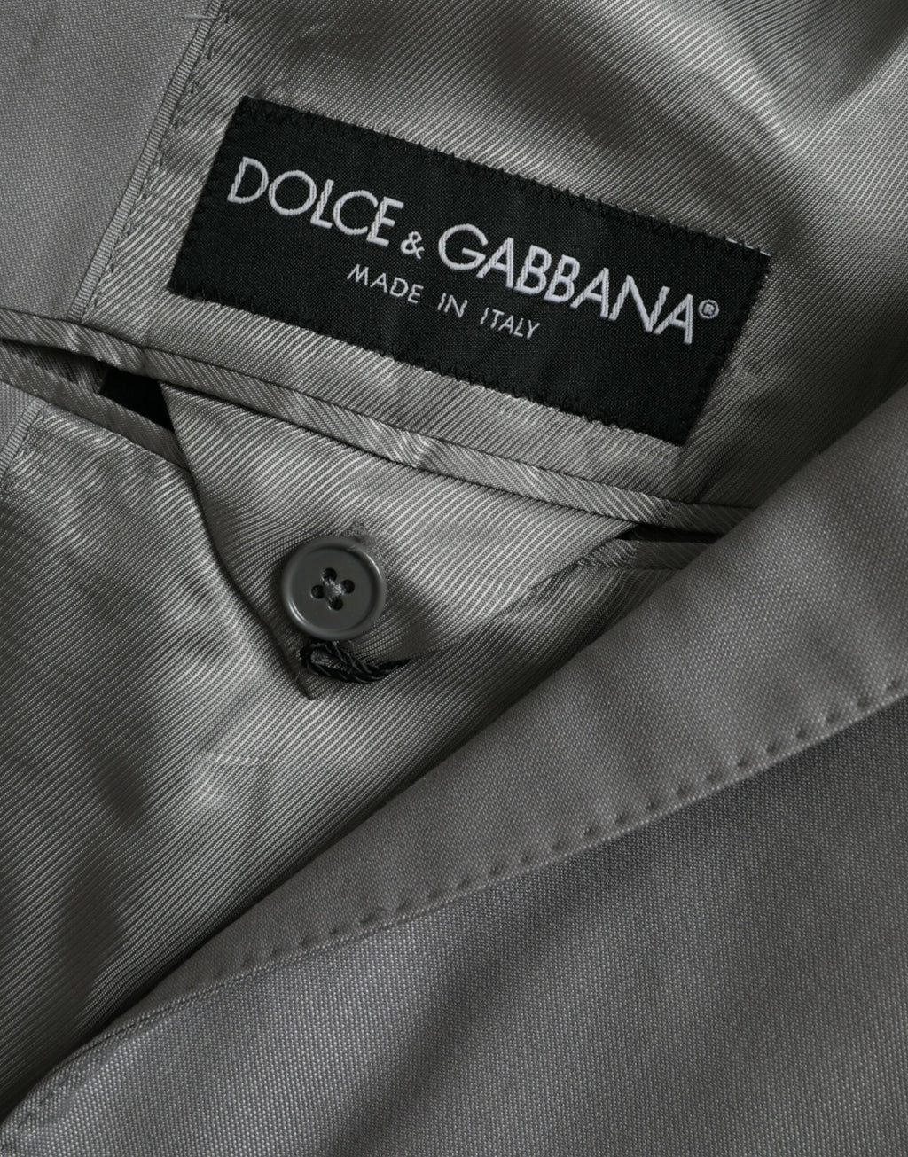Manteau en laine gris Dolce & Gabbana, blazer à col cranté avec boutonnière simple, porté en image.