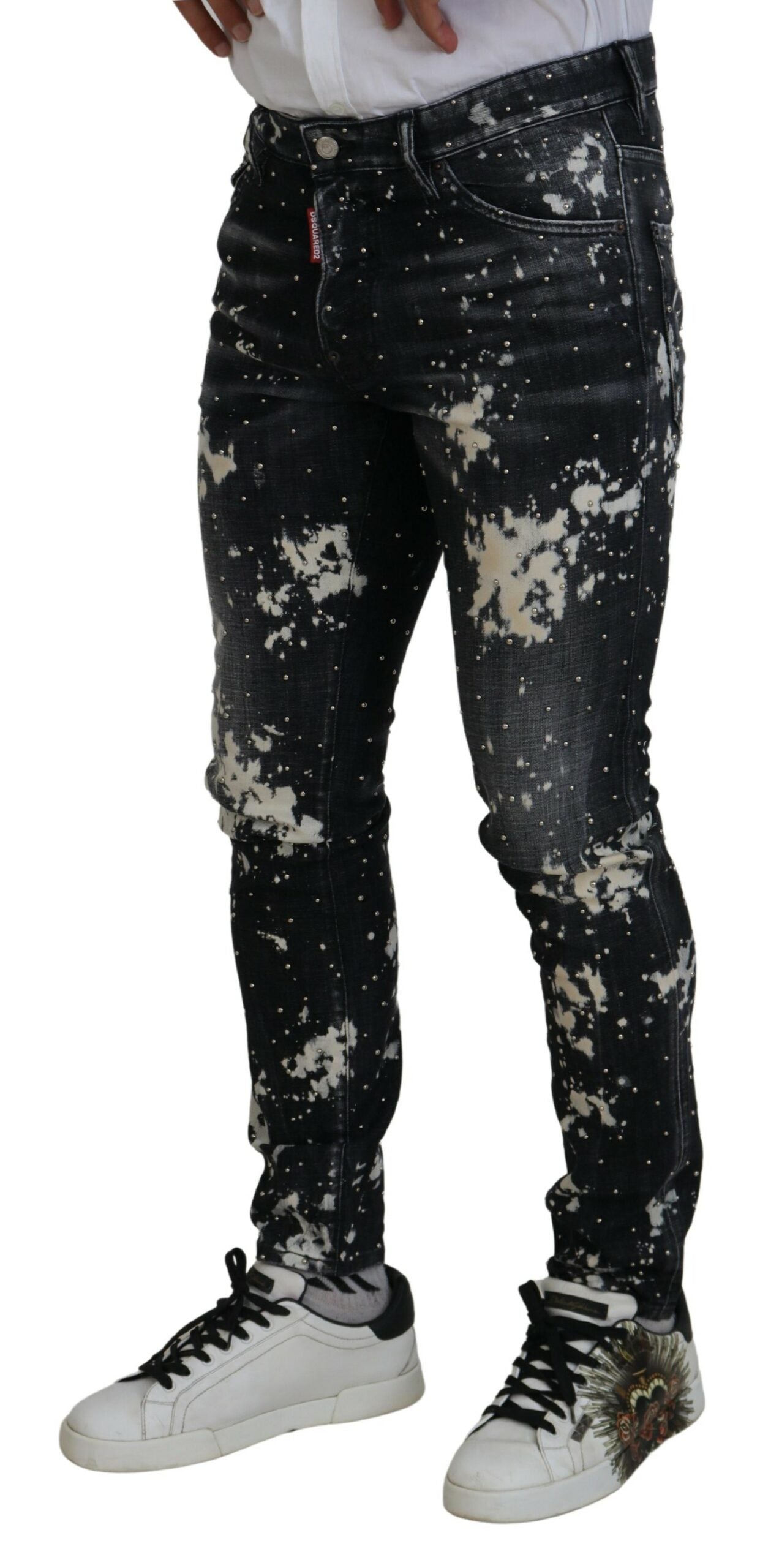 Jeans décontractés en denim blanc délavé avec éclaboussures de couleur, par Dsquared², montrant la coupe et la texture du tissu.
