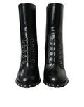 Bottes noires en cuir avec clous, lacées, de la marque Dolce & Gabbana, visibles en gros plan.